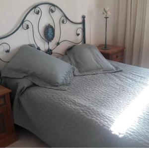 a bedroom with a bed with gray sheets and pillows at Departamento Punta del Este parada 16 La Mansa in Punta del Este