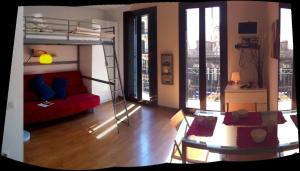 uma sala de estar com um beliche e um sofá vermelho em Studio by Sants Market em Barcelona