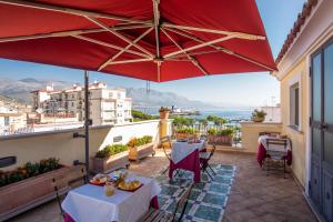 a patio with tables and a large red umbrella at Il Quartuccio Gaeta in Gaeta