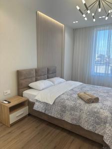 - une chambre avec un grand lit et une fenêtre dans l'établissement LUX Apartment Av.Iancu floor6, à Chişinău
