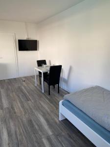 a bedroom with a table and a bed and a television at Apartmenthaus Selbitz in Selbitz