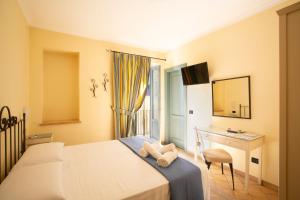 a bedroom with a bed and a desk and a window at Il Quartuccio Gaeta in Gaeta