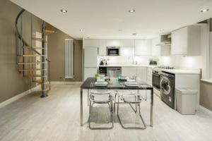 a kitchen with a table and two stools at Central, Kensington, 3Beds, Cosy, Parks, Pubs in London