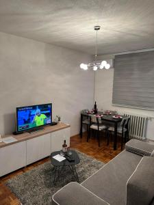 多博伊Apartman Tamara的带沙发、电视和桌子的客厅