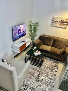 a living room with a couch and a flat screen tv at Mars cozy apartment in Dar es Salaam