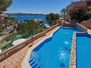 a beach with a pool and a swimming pool at Hotel Petit Cala Fornells in Paguera