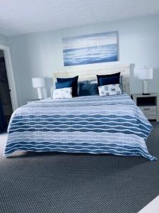 a large bed with a blue and white striped blanket at Gorgeous OceanView-Jacuzzi ChelseaHouse in Myrtle Beach
