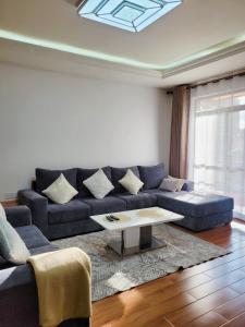 a living room with a blue couch and a coffee table at Stunning and serene homes in Nairobi