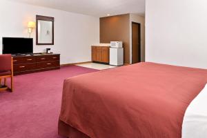 a hotel room with a bed and a television at America's Best Value Inn Beardstown in Beardstown