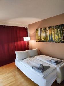 a bedroom with a white bed and a red curtain at Apartment Bergzauber - traumhafter Ausblick & Pool in Braunlage