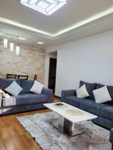 a living room with two blue couches and a coffee table at Stunning and serene homes in Nairobi