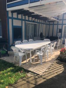 une table et des chaises blanches devant une maison dans l'établissement Les Wyllos, à Thiéblemont-Farémont