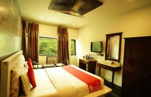 a bedroom with a bed and a desk and a window at RoyalVilla in Chandīgarh