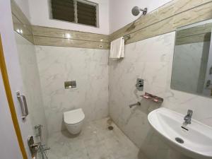 海得拉巴的住宿－HOTEL PLAZA ROOMS，白色的浴室设有水槽和卫生间。