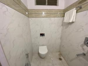 海得拉巴的住宿－HOTEL PLAZA ROOMS，白色的浴室设有卫生间和淋浴。