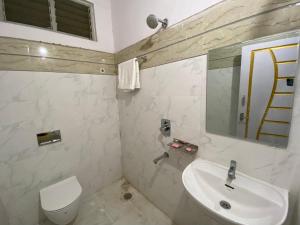 ハイデラバードにあるHOTEL PLAZA ROOMSのバスルーム(洗面台、トイレ、鏡付)