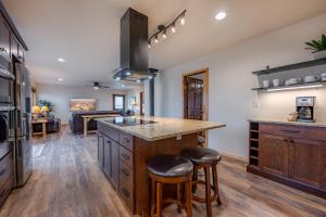 a kitchen with a large island with stools at Buena Vista Mountain Retreat - Ultimate Privacy with Spa & Unbeatable Views in Buena Vista