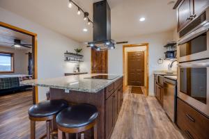a kitchen with a large island with two stools at Buena Vista Mountain Retreat - Ultimate Privacy with Spa & Unbeatable Views in Buena Vista