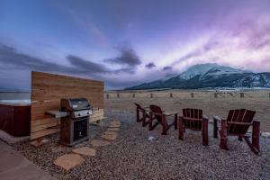 a group of chairs and a stove with mountains in the background at Buena Vista Mountain Retreat - Ultimate Privacy with Spa & Unbeatable Views in Buena Vista