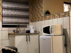 a kitchen with a microwave on top of a refrigerator at Makobaneng Guesthouse in Ga-Raphokola