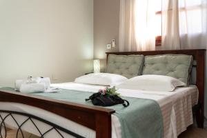 een slaapkamer met een groot bed met een handtas erop bij Happinest Private Apartment in Kalymnos