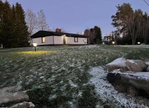 a house in a field with snow on the ground at Pieni omakotitalo joen rannalla in Rautio
