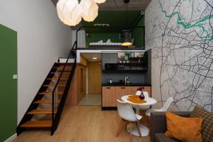 a living room and kitchen with a staircase and a table at Wrocław Airport Green Studio in Wrocław