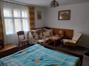a bedroom with a bed and a couch and a table at Chalupa Na Křemence in Třinec