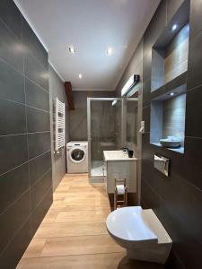 a bathroom with a toilet and a sink and a washing machine at Apartament w sercu Krakowa in Kraków