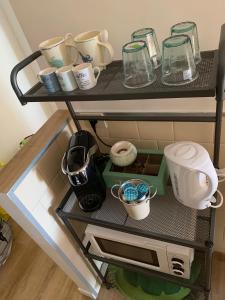 a shelf with cups and other items on it at Casa VerdeMare in Lido di Ostia