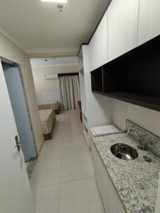 eine kleine Küche mit einem Waschbecken in einem Zimmer in der Unterkunft Caldas Novas - 2024 - diRoma Spazzio acesso ao Vulcão - com Piscina do hotel 24 horas in Caldas Novas