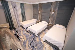 dwa łóżka w pokoju z rozbitą podłogą w obiekcie Khan Palace2 w mieście Türkistan
