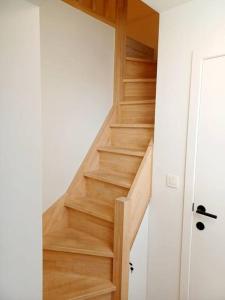 Una escalera de madera en una habitación con puerta en Modern en sfeervol appartement aan de Zoete Waters en Oud-Heverlee