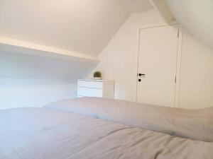a white bedroom with a bed and a white cabinet at Modern en sfeervol appartement aan de Zoete Waters in Oud-Heverlee