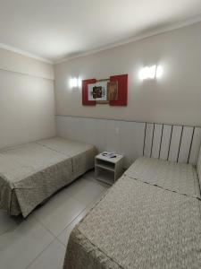1 dormitorio con 2 camas y una mesa pequeña en Caldas Novas - 2024 - diRoma Spazzio acesso ao Vulcão - com Piscina do hotel 24 horas en Caldas Novas
