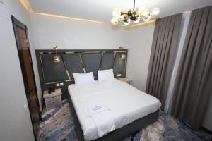 sypialnia z białym łóżkiem z czarnym zagłówkiem w obiekcie Khan Palace2 w mieście Türkistan