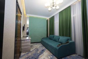 salon z niebieską kanapą i telewizorem w obiekcie Khan Palace2 w mieście Türkistan