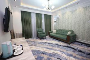 salon z zieloną kanapą i 2 krzesłami w obiekcie Khan Palace2 w mieście Türkistan