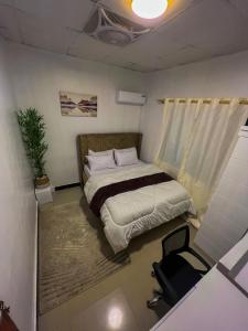 a bedroom with a bed and a chair in it at Mars cozy apartment in Dar es Salaam
