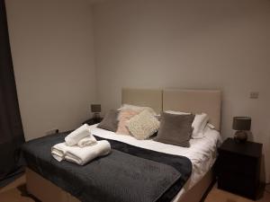 a bedroom with a large bed with towels on it at Heritage Place by Select SA in Reading