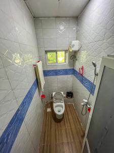 a small bathroom with a toilet and a window at Mars cozy apartment in Dar es Salaam
