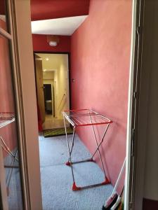 Zimmer mit einer roten Wand und einem Glastisch in der Unterkunft Appartamento Le Rondini A in Intra