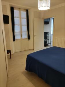 ein Schlafzimmer mit einem blauen Bett und einem Fenster in der Unterkunft Appartamento Le Rondini A in Intra