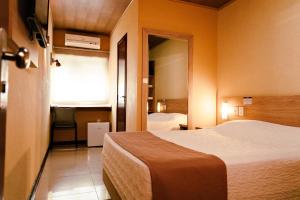 a hotel room with a bed and a window at Pousada Costa Doce in Rio Grande