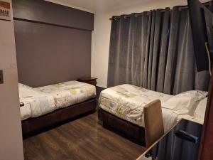 a room with two beds and a window at Hotel Terrasol Iquique in Iquique