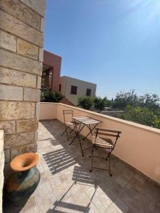 a patio with chairs and a table on a balcony at La nymphe Aegina in Áyioi Asómatoi