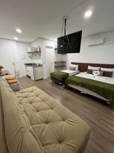 Cette grande chambre comprend 2 lits et un canapé. dans l'établissement SeuLar o conforto de um Lar em Qualquer Lugar, à São Paulo
