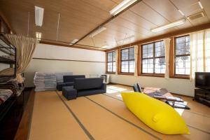 a living room with a yellow surfboard on the floor at Mori no Bunkou Fuzawa - Vacation STAY 86824v in Kobayashi