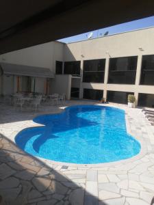 a large blue swimming pool in front of a building at POUSADA MINEIRA in Águas de São Pedro