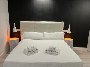 Una cama blanca con dos toallas encima. en H. Pelayo Autocheck-In Suites con Jacuzzi, en Noja